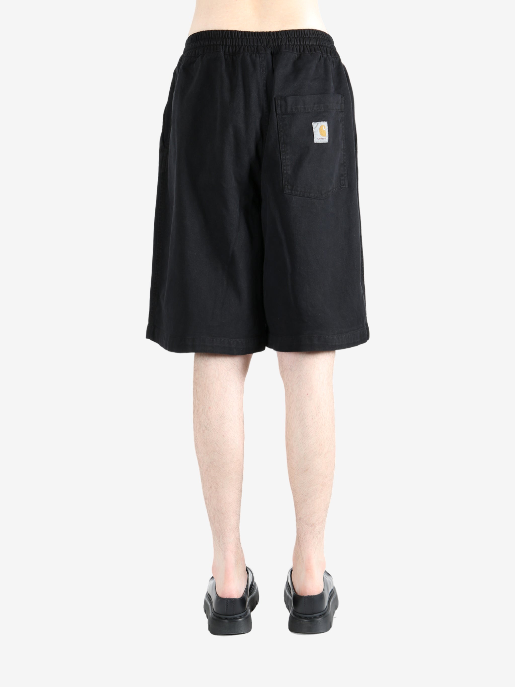 Black short worn by a person, showing the short's fit