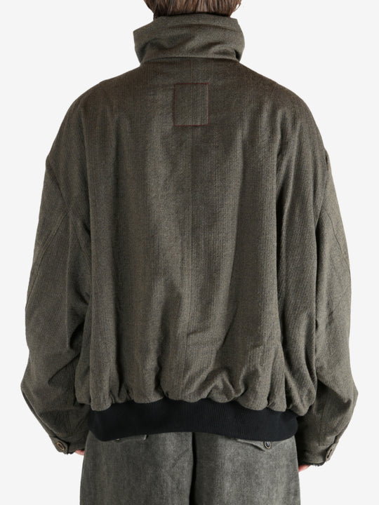 Green jacket worn by a person, showing the jacket's fit