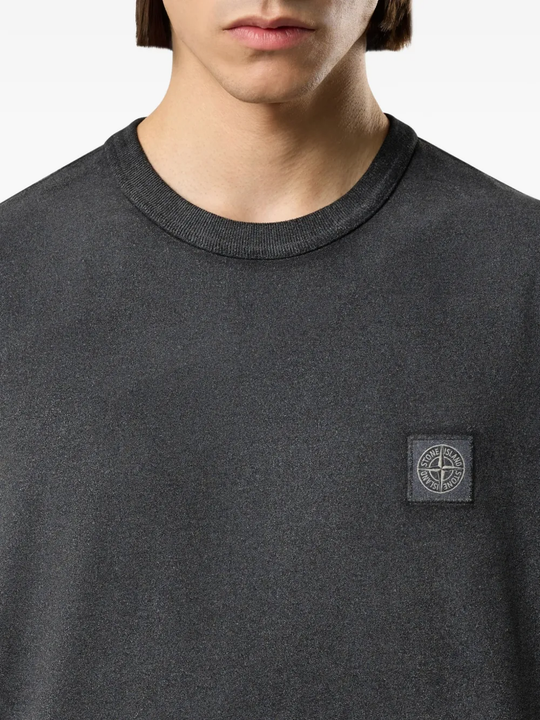 Close up of the black t-shirt, showing texture of the cotton fabric