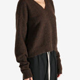 Brown knitwear worn by a person, showing the knitwear's fit
