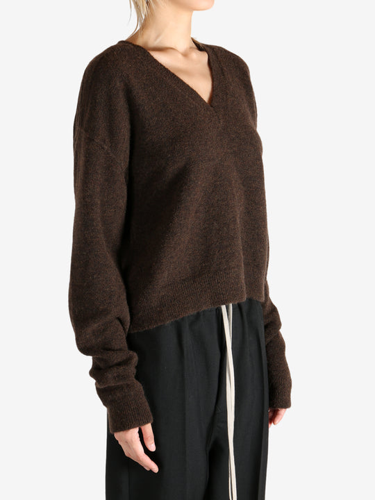 Brown knitwear worn by a person, showing the knitwear's fit
