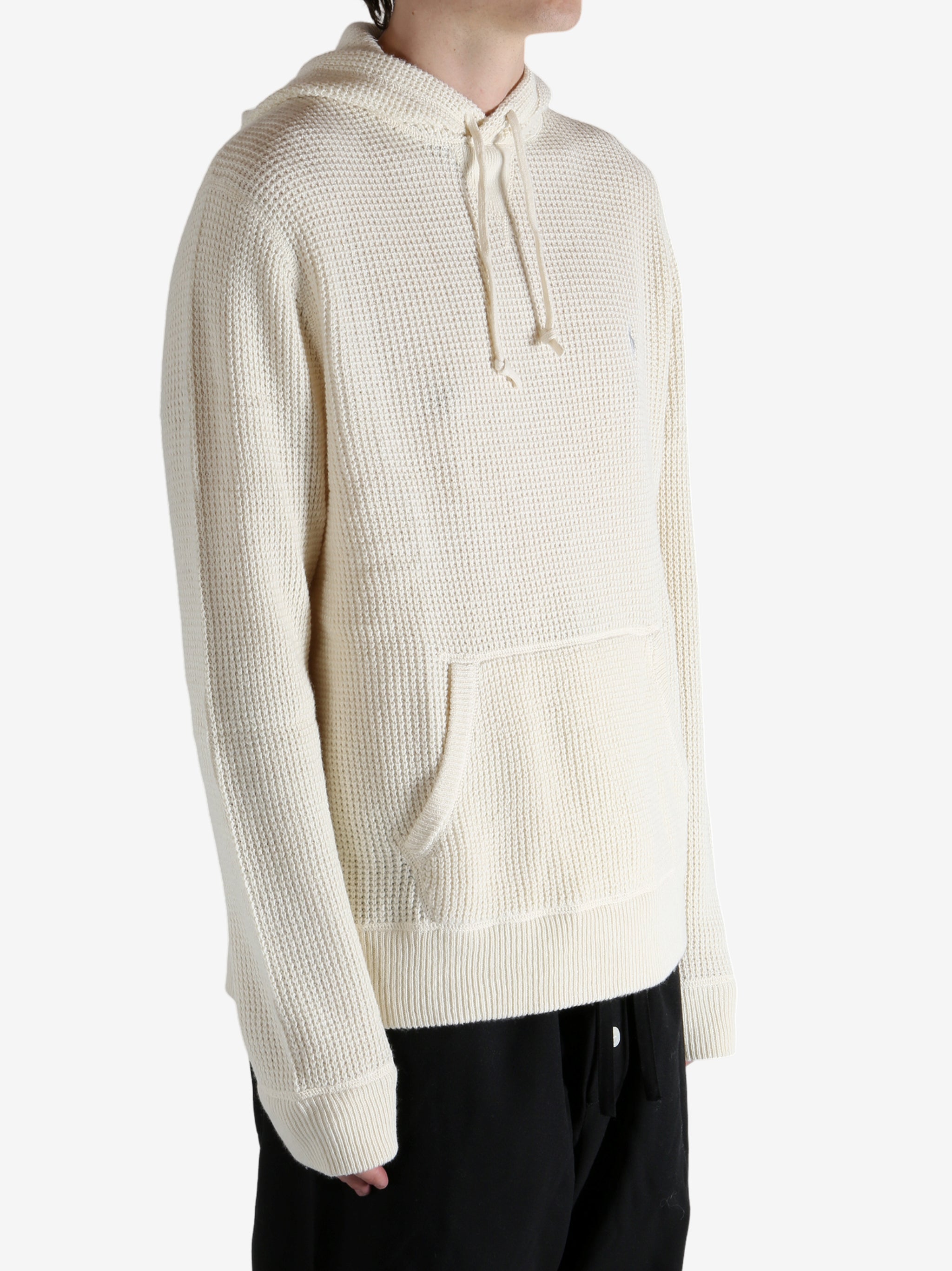 White knitwear worn by a person, showing the knitwear's fit