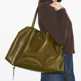 Person holding a large green handbag against a white background