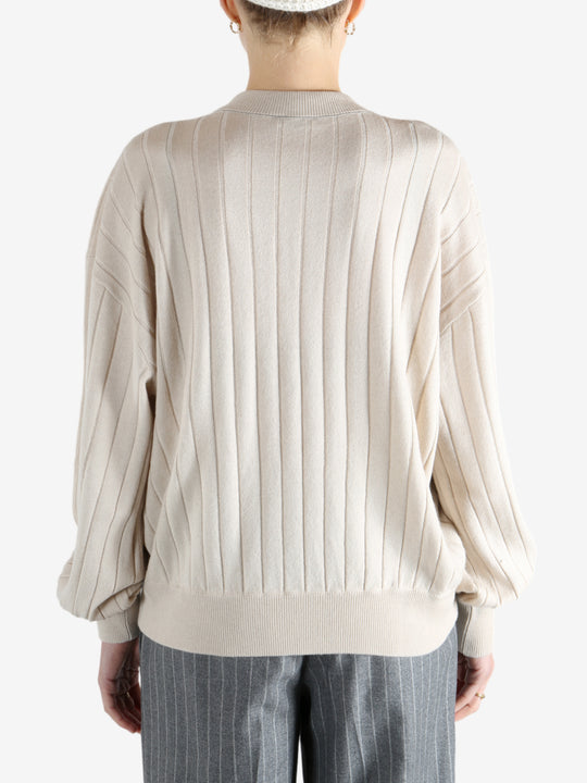 Grey knitwear worn by a person, showing the knitwear fit