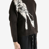 Black sweater worn by a person, showing the sweater's fit