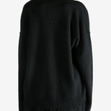 Black knitwear worn by a person, showing the knitwear's fit