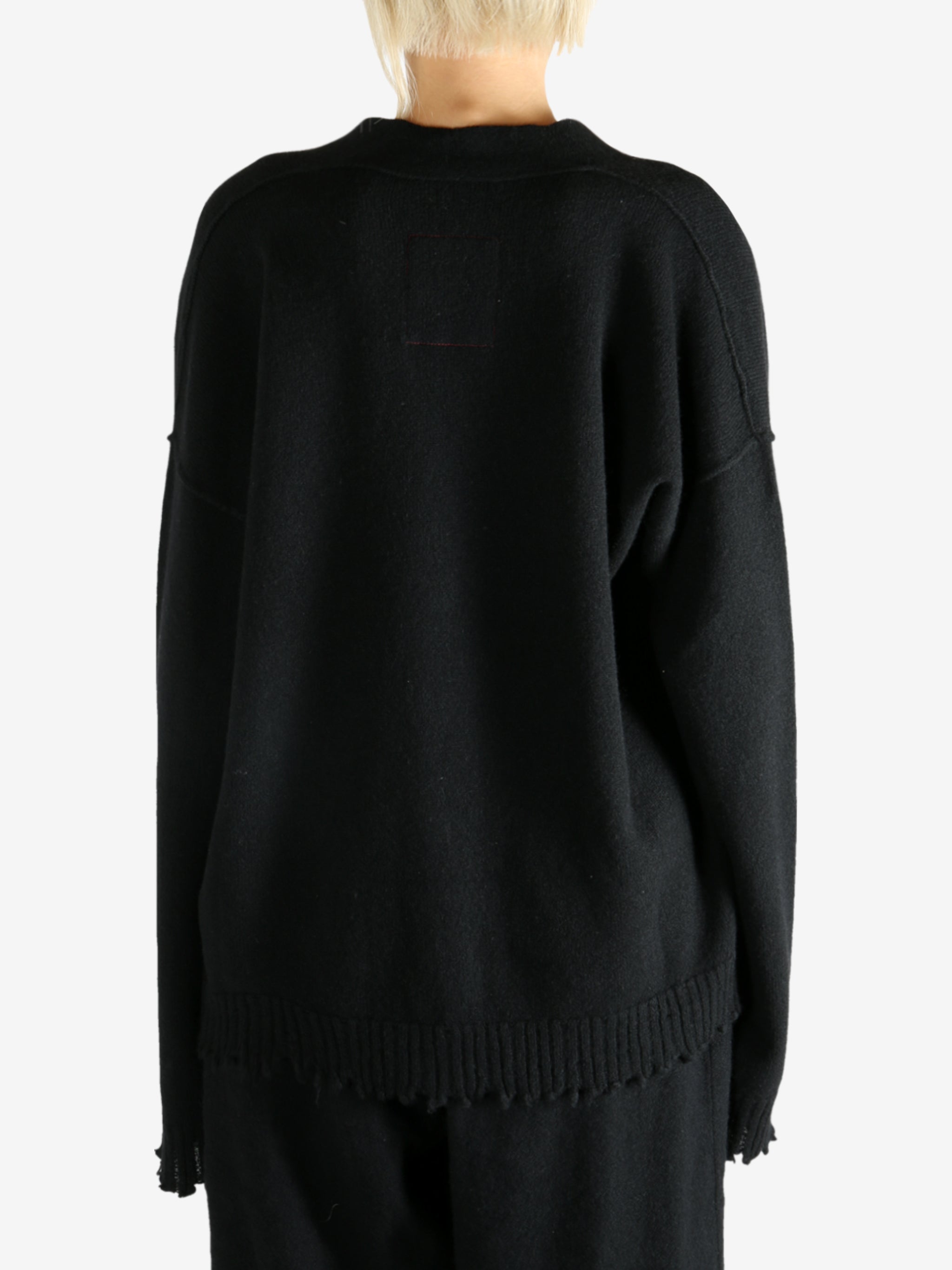 Black knitwear worn by a person, showing the knitwear's fit