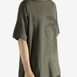 Green t-shirt worn by a person, showing the t-shirt's fit