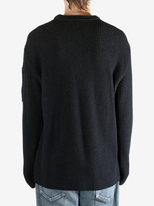 Black sweater worn by a person, showing the sweater fit