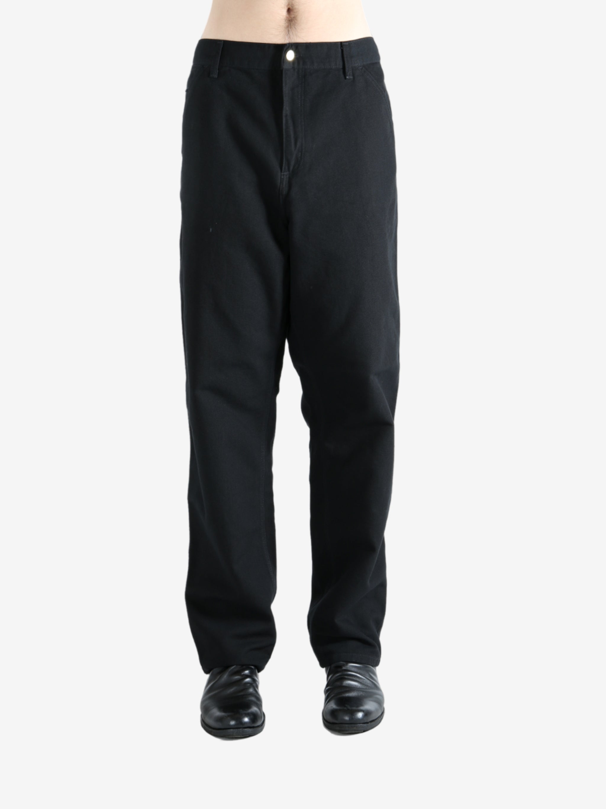 Black pants worn by a person, showing the pants' fit