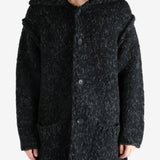 Black coat worn by a person, showing the coat's fit