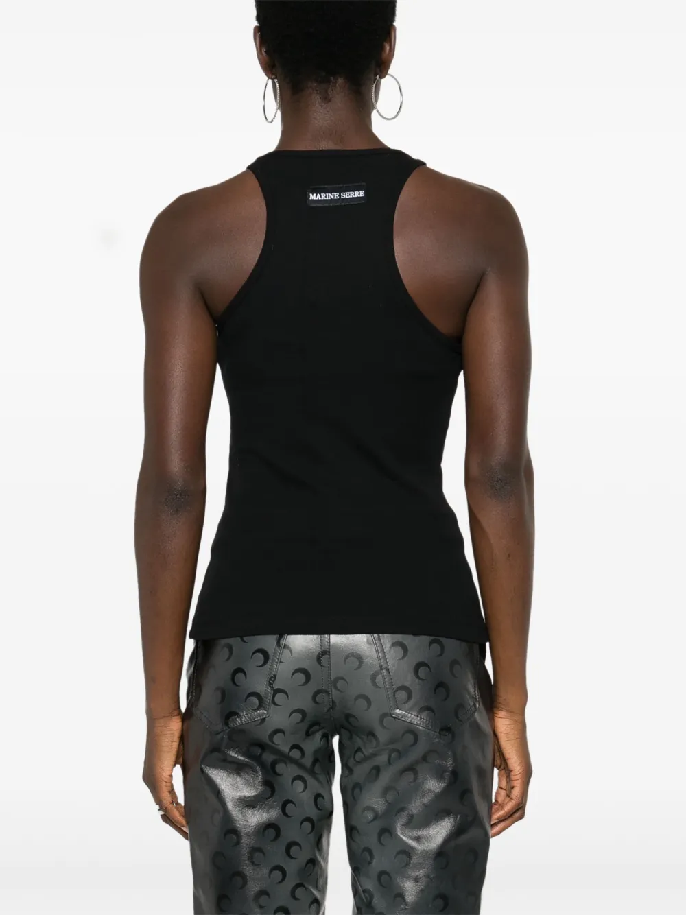 Black tops worn by a person, showing the tops' fit