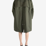 Green coat worn by a person, showing the coat fit