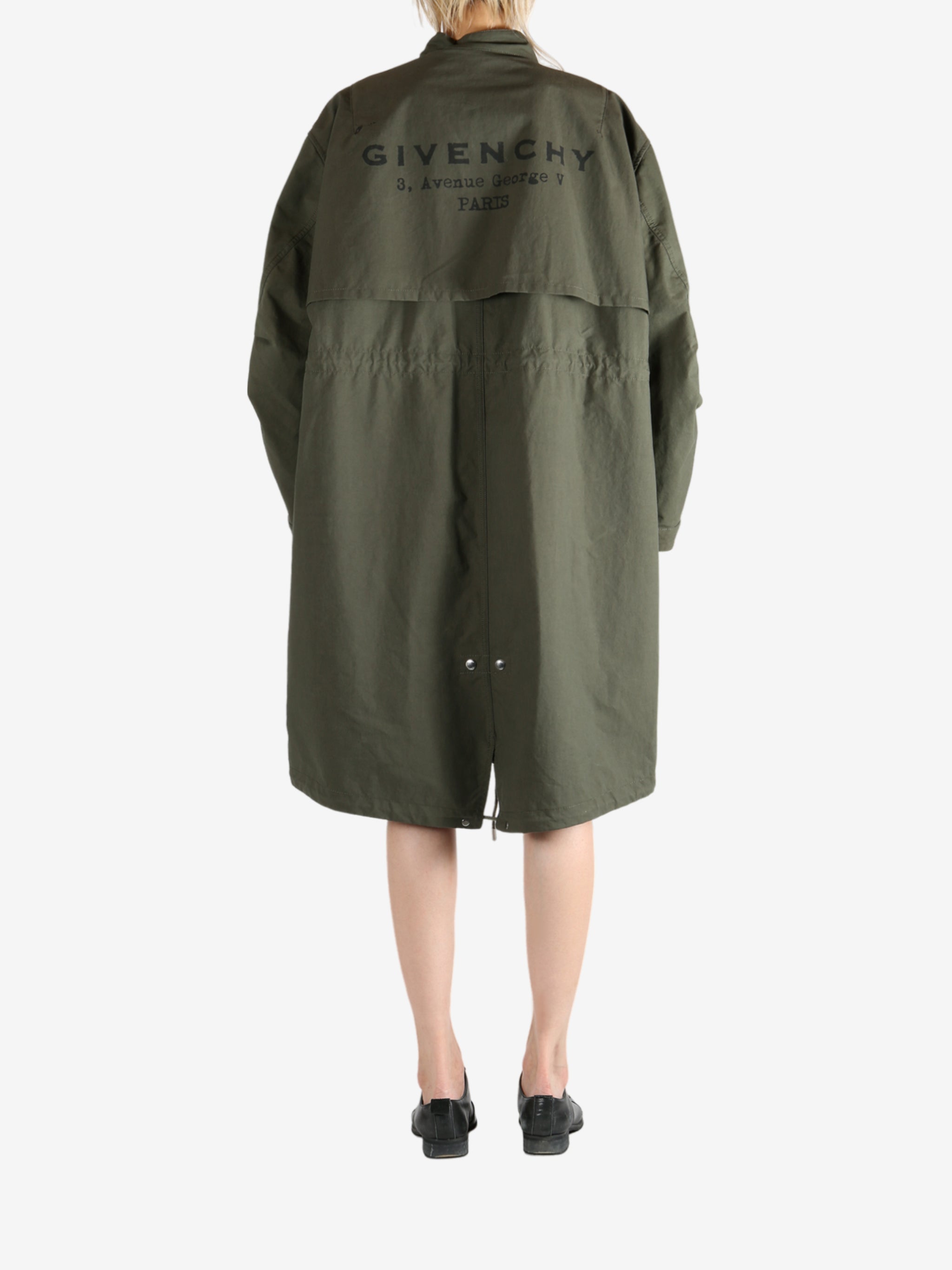 Green coat worn by a person, showing the coat fit