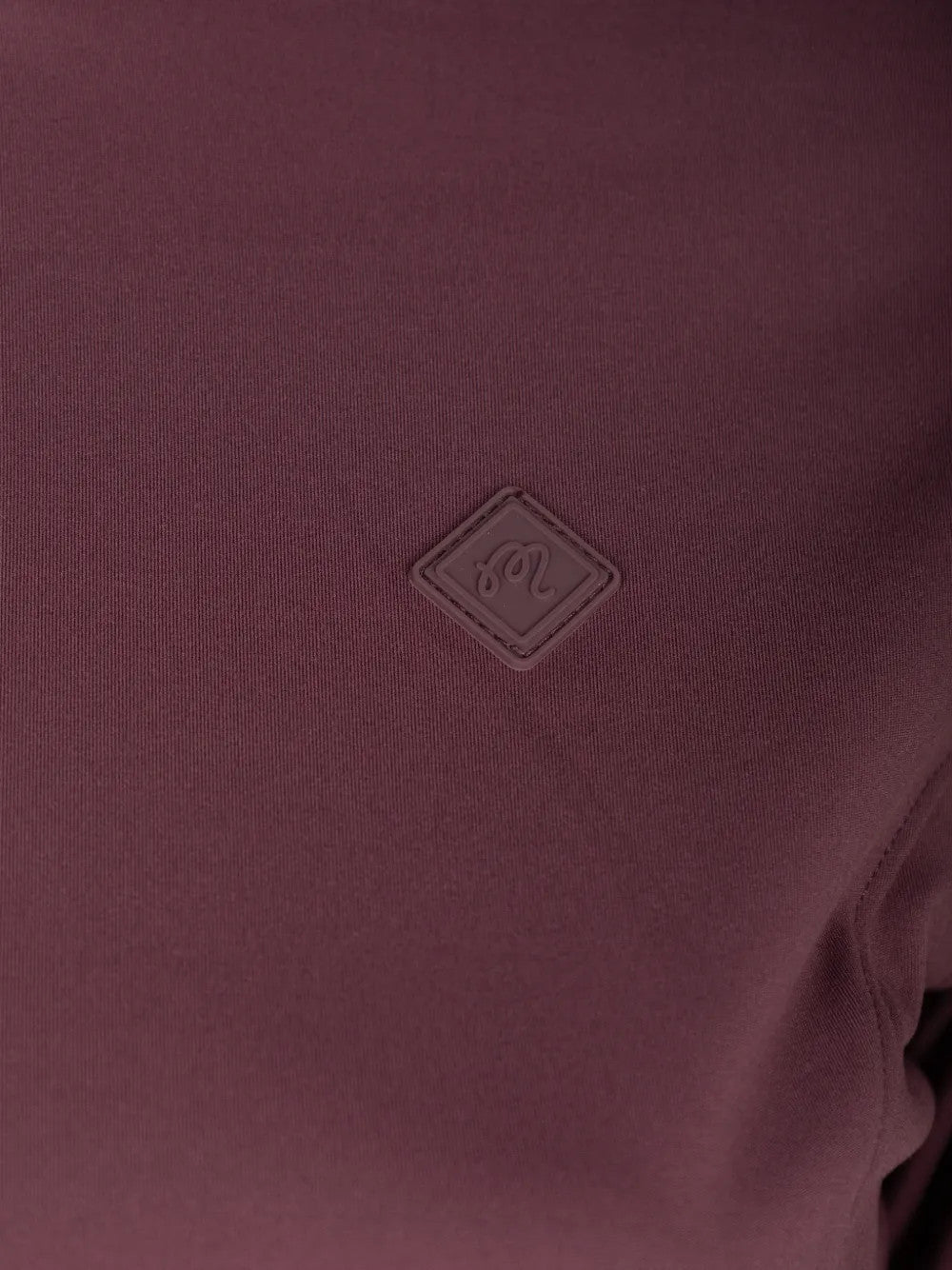 Close up of Burgundy jacket, showing texture of the 70% recycled polyester/ 30% elastane made in fabric