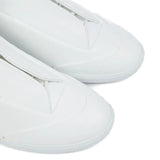 Close up of white sneakers, showing texture of the calf leather and rubber fabric