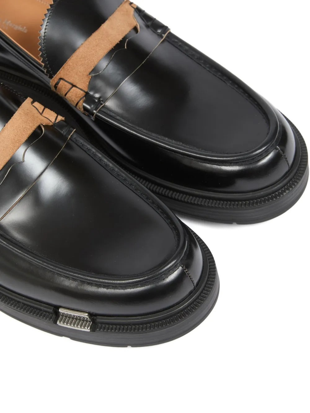Close up of the black loafer, showing texture of the leather fabric