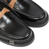 Close up of the black loafer, showing texture of the leather fabric