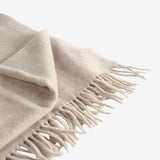 Close up of tan scarves, showing texture of the wool fabric