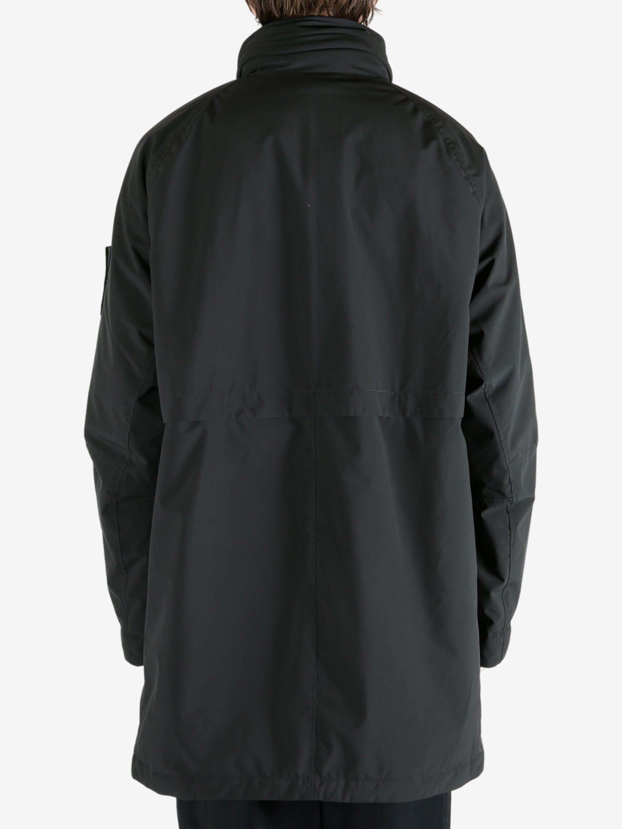 Black coat worn by a person, showing the coat fit