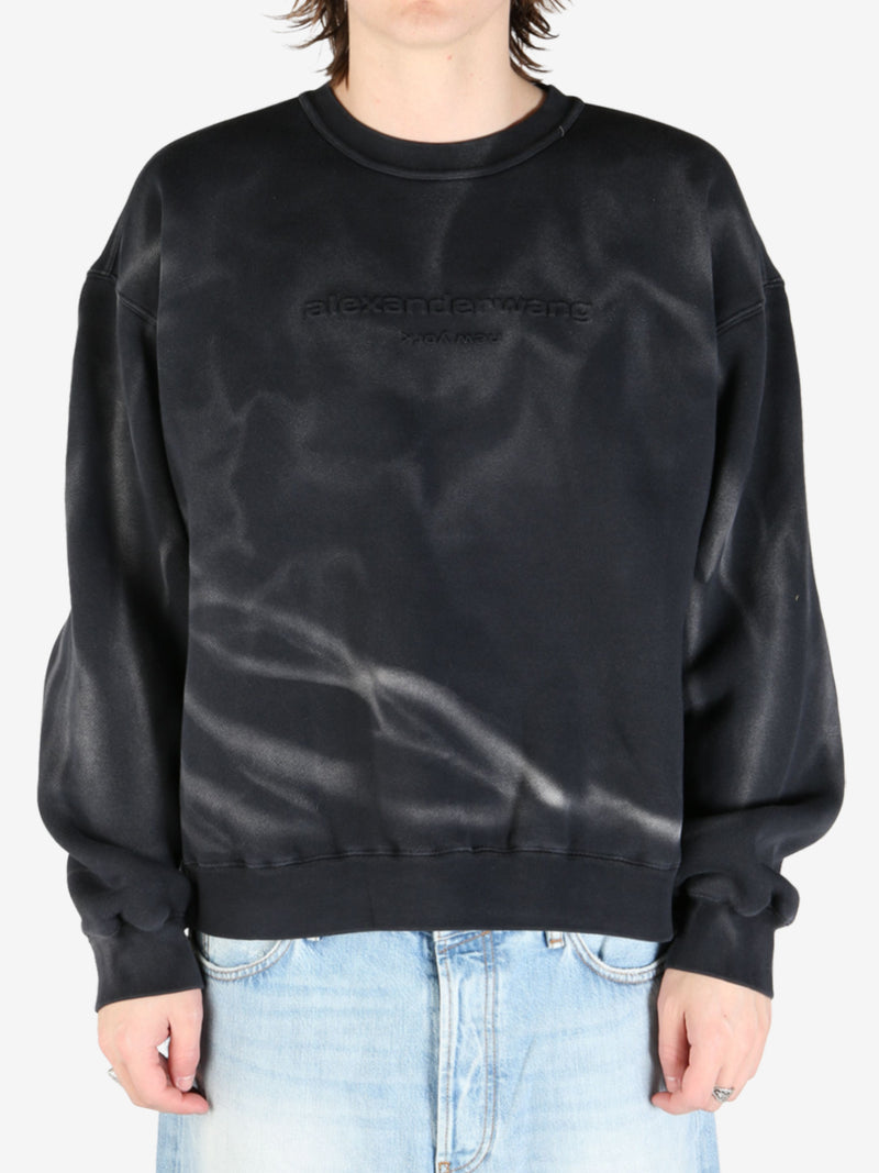 Black sweatshirt worn by a person, showing the sweatshirt's fit