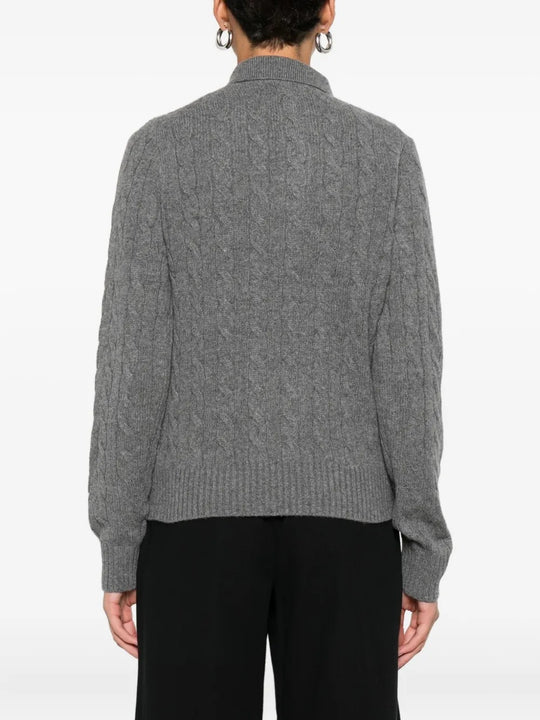 Grey knitwear worn by a person, showing the knitwear's fit