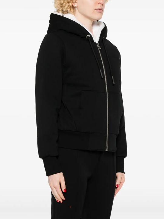 Black coat worn by a person, showing the coat fit