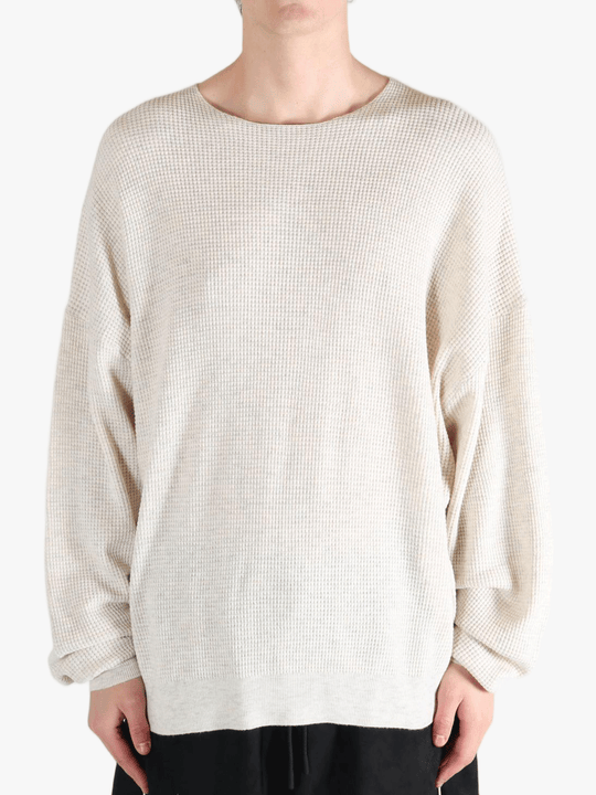 White sweater worn by a person, showing the sweater's fit