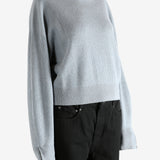 Blue knitwear worn by a person, showing the knitwear's fit