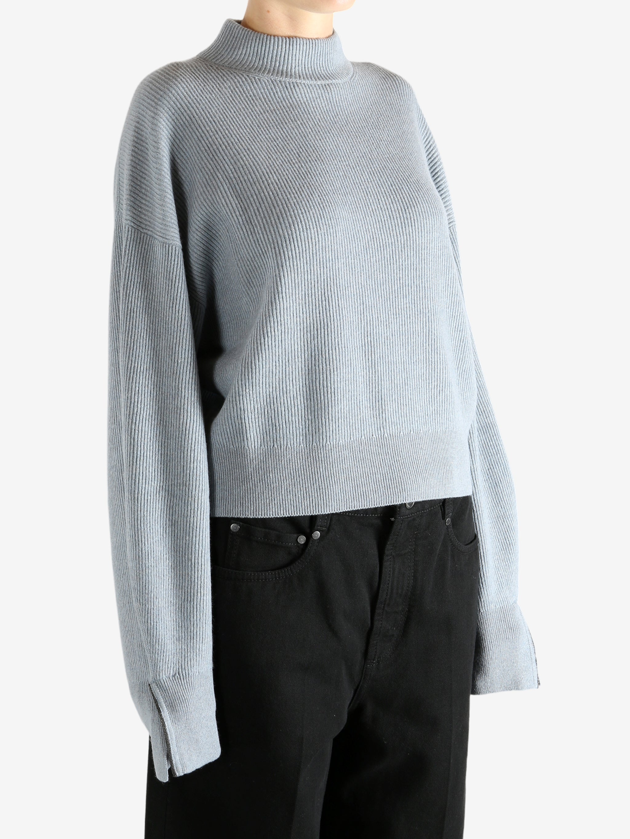 Blue knitwear worn by a person, showing the knitwear's fit