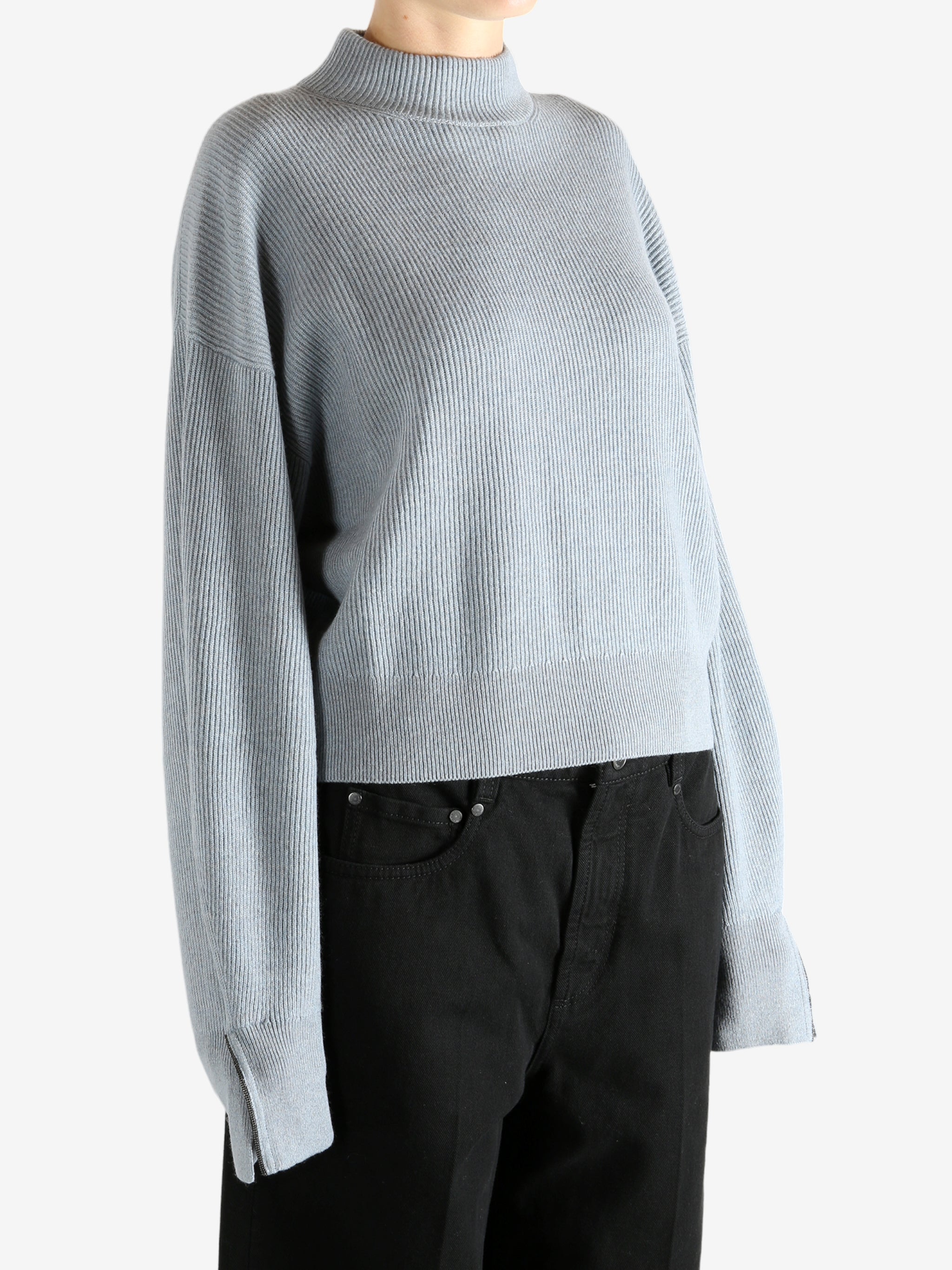 Blue knitwear worn by a person, showing the knitwear's fit