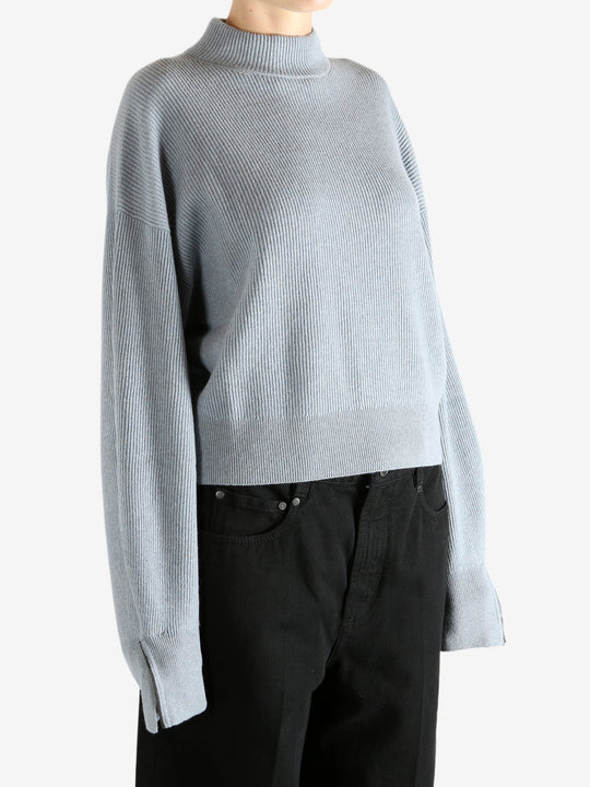 Blue knitwear worn by a person, showing the knitwear's fit