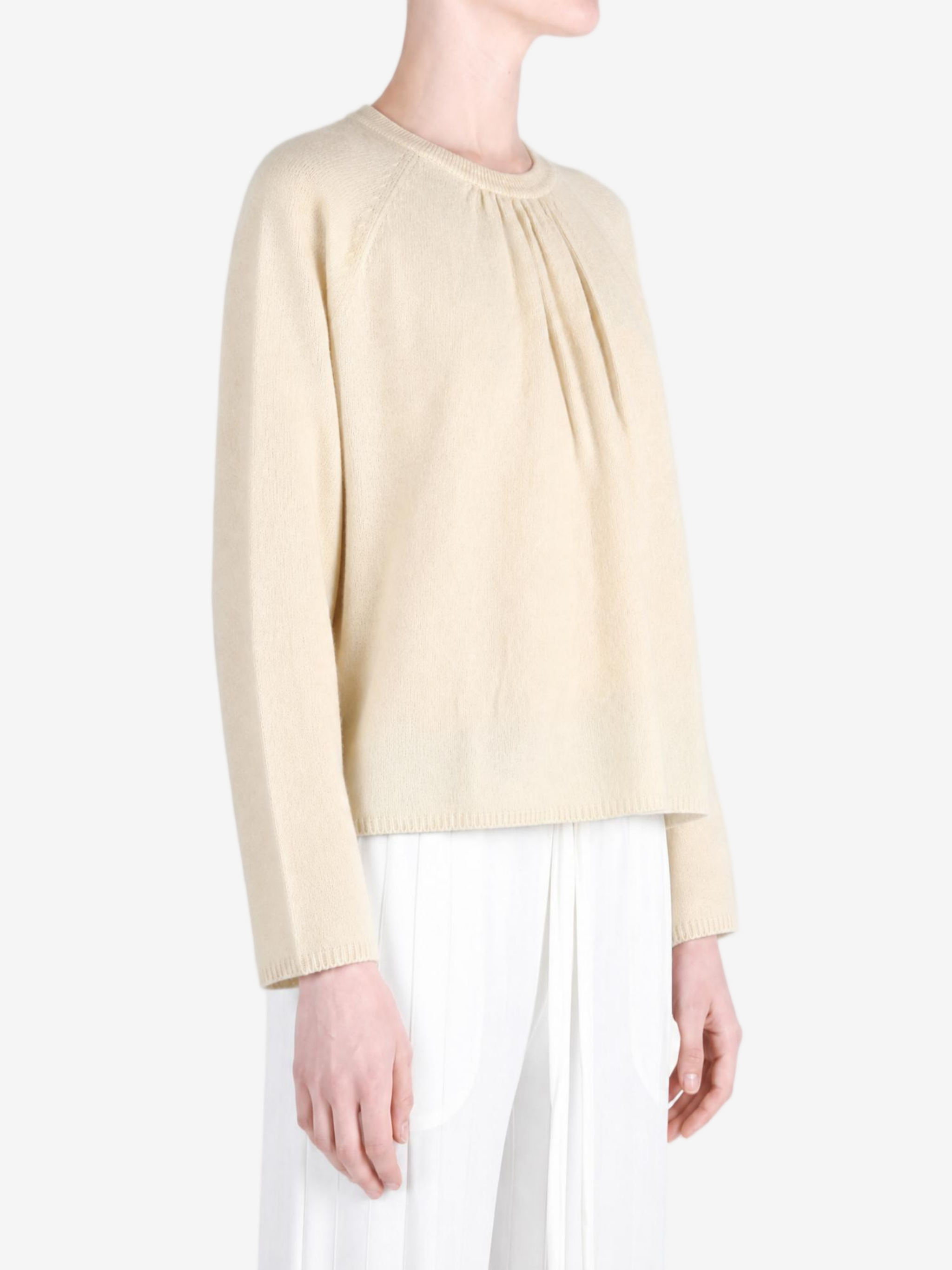 Tan knitwear worn by a person, showing the knitwear fit