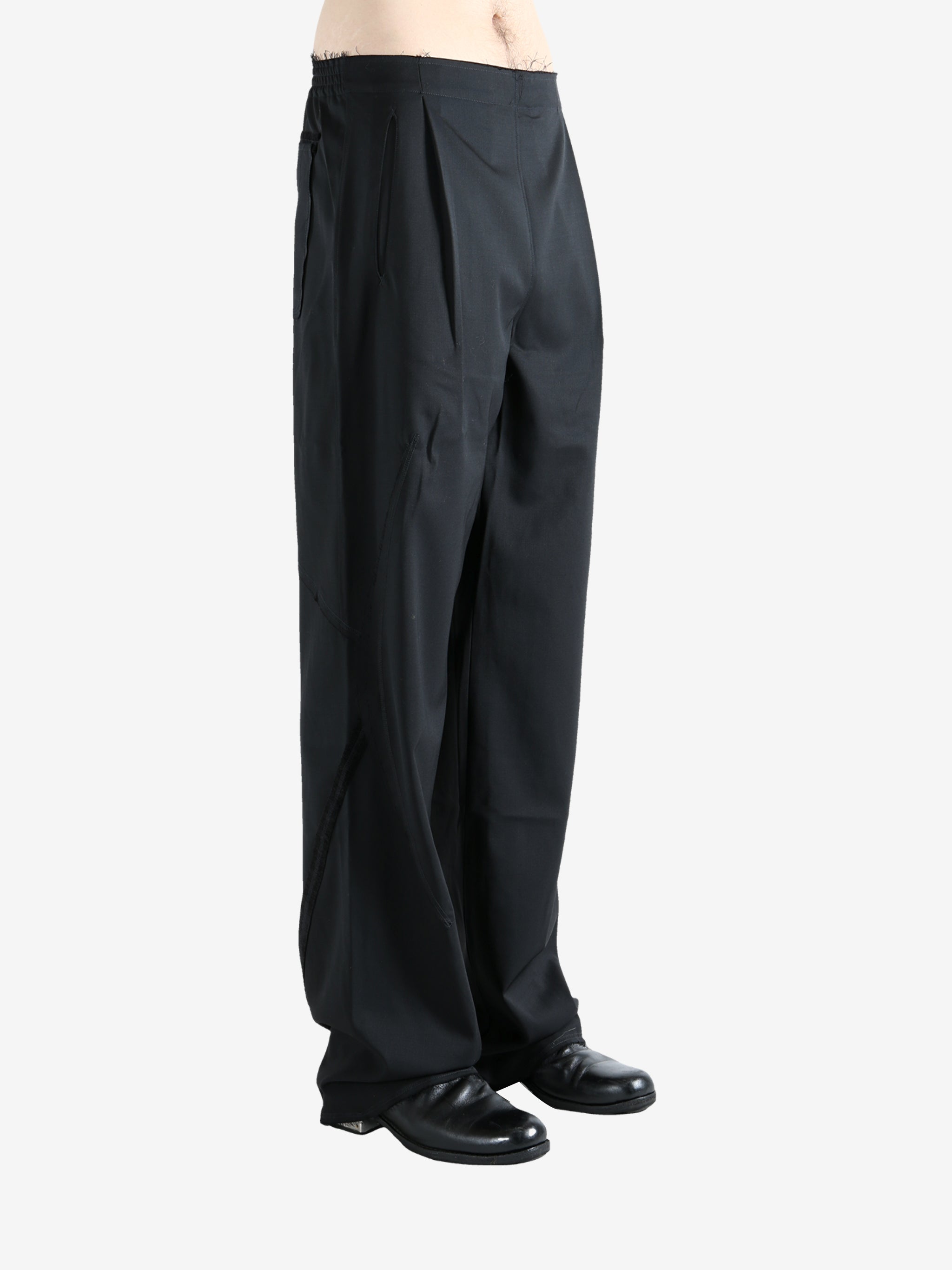 Black pants worn by a person, showing the pants' fit