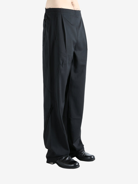 Black pants worn by a person, showing the pants' fit