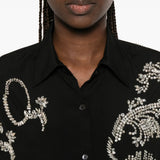 Black shirt worn by a person, showing the shirt fit