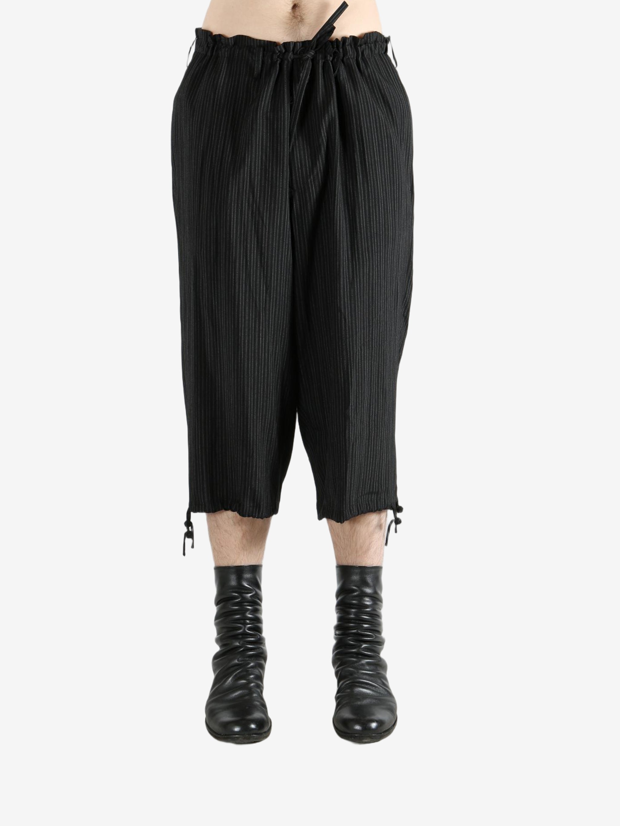 Black pants worn by a person, showing the pants's fit