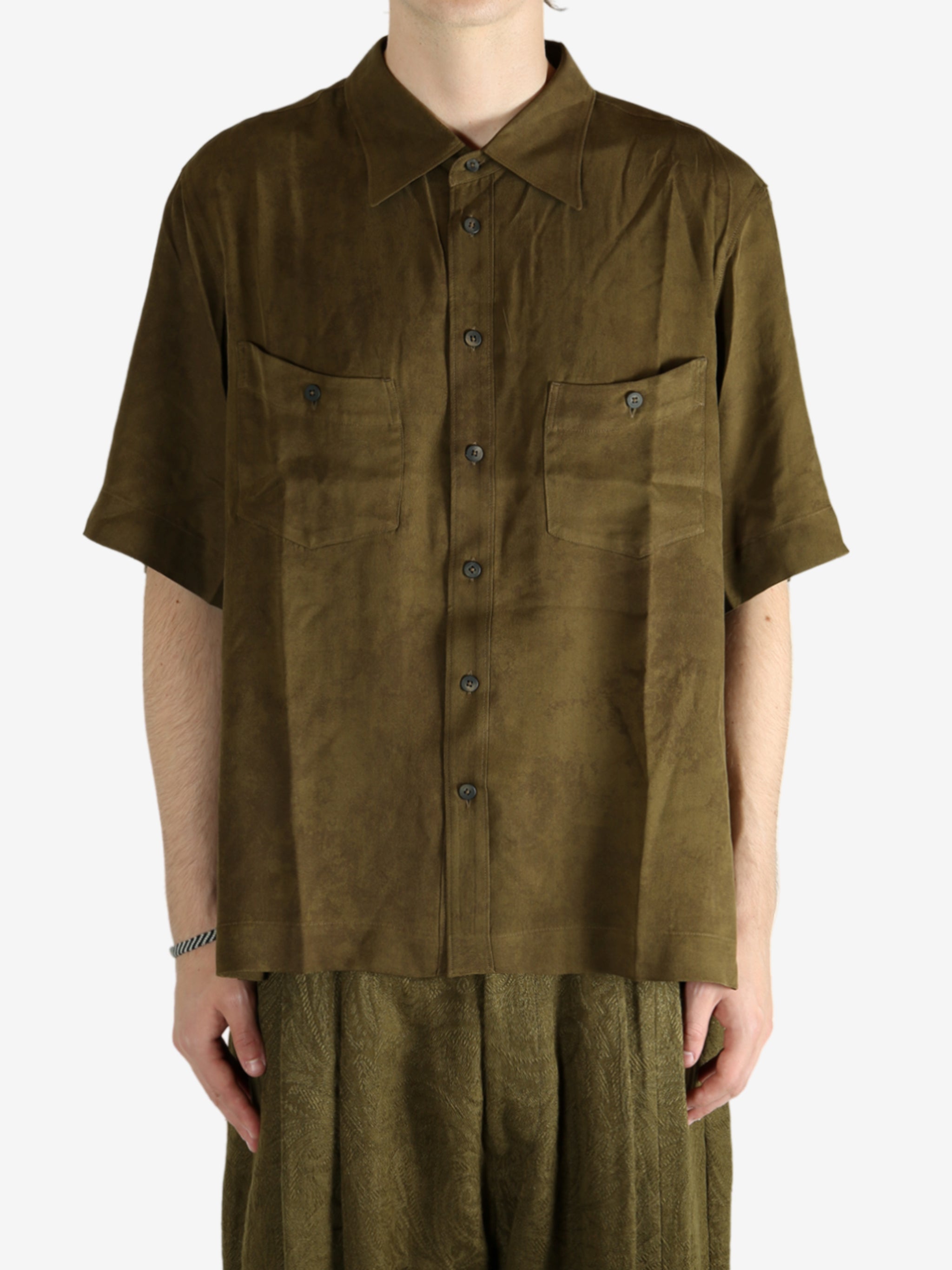 Green shirt worn by a person, showing the shirt's fit