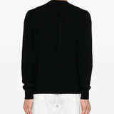 Black sweater worn by a person, showing the sweater fit