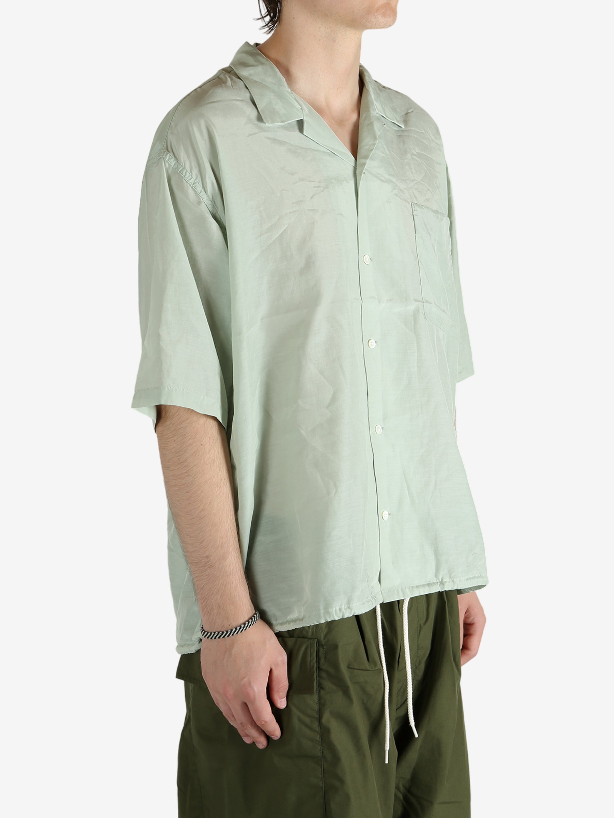 Green shirt worn by a person, showing the shirt's fit