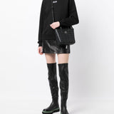 Black bag carried by a person, showing the bag's fit