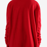 Red knitwear worn by a person, showing the knitwear's fit