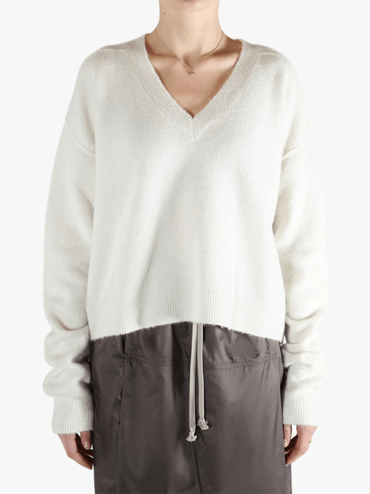 White sweater worn by a person, showing the sweater fit