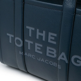 Close up of navy bags, showing texture of the leather fabric