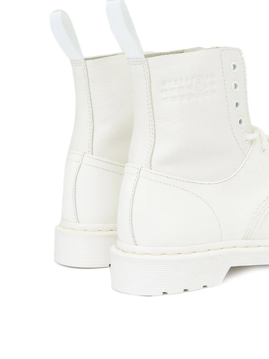 Close up of the white boots, showing texture of the rubber and leather fabric