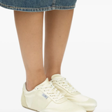 Tan sneakers worn by a person, showing the sneakers fit