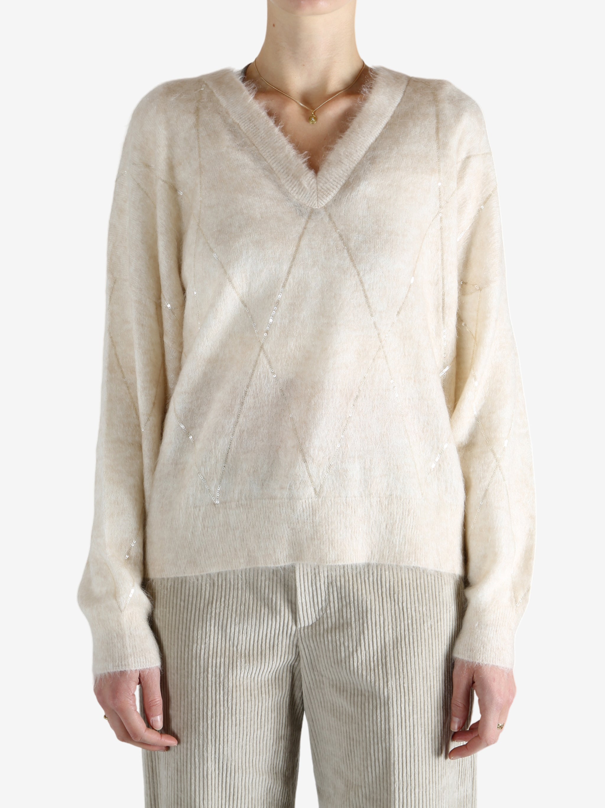 Tan knitwears worn by a person, showing the knitwears fit