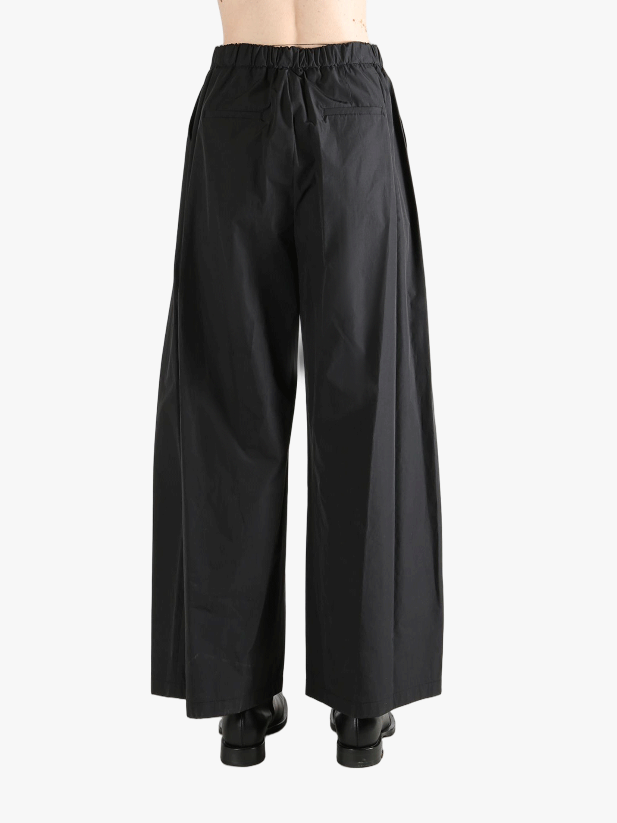 Black pants worn by a person, showing the pants fit