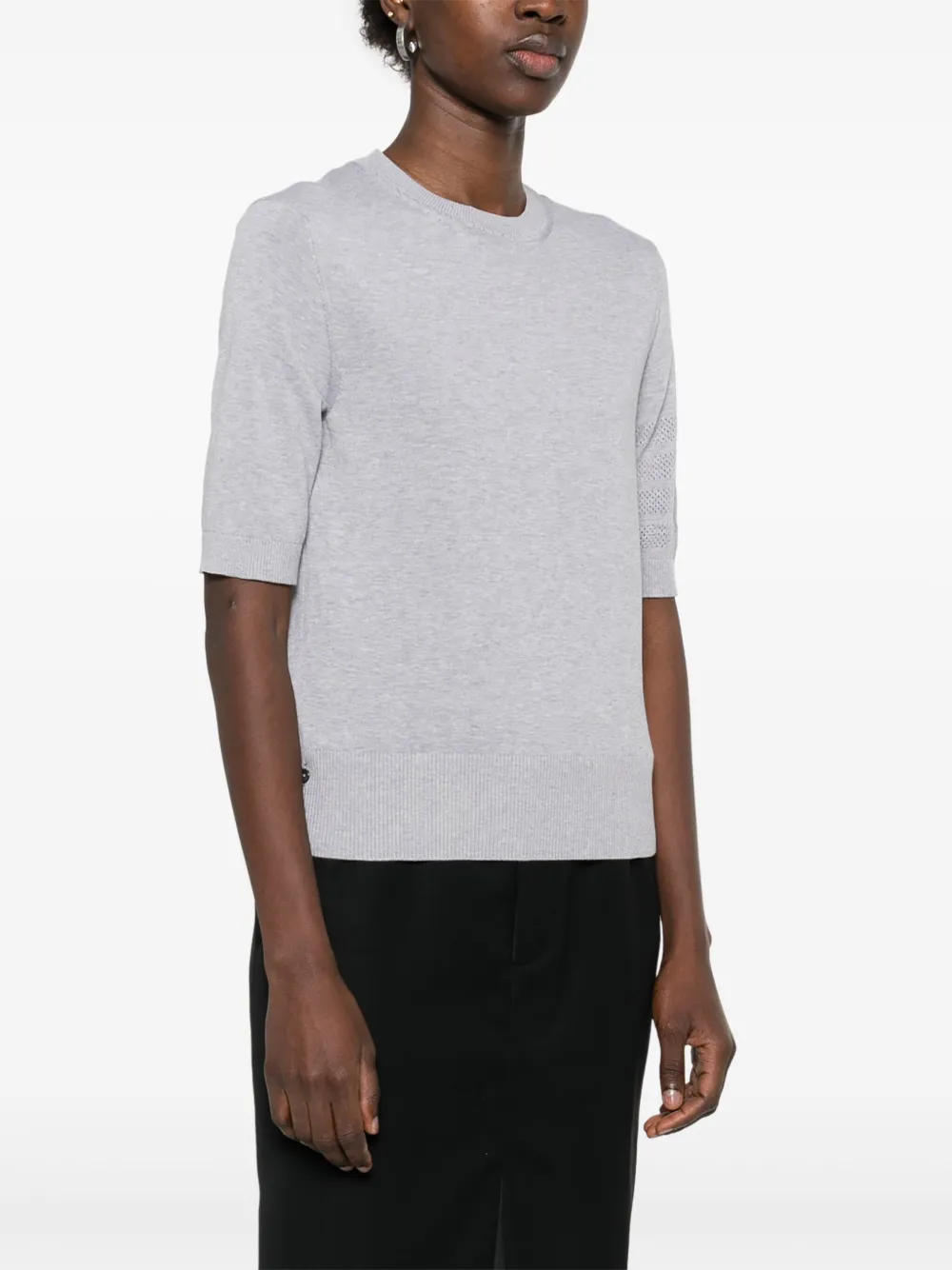 Grey t-shirt worn by a person, showing the cotton fit