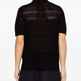 black knitwear worn by a person, showing the knitwear fit